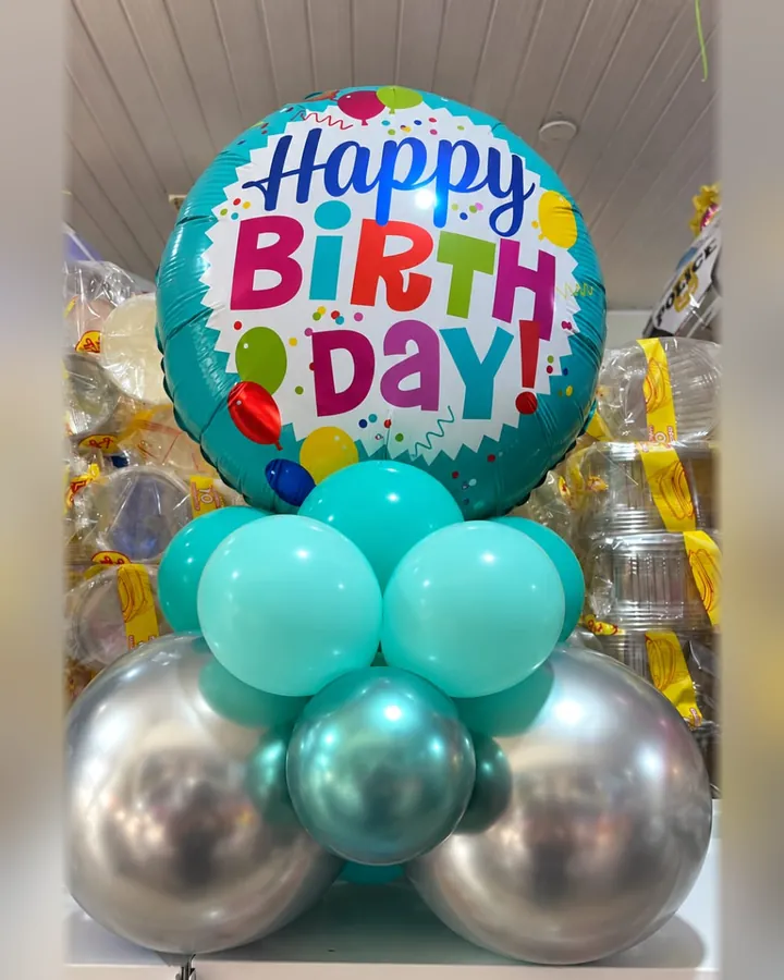 Balão Happy Birthday colorido com base de balões turquesa e prateados.