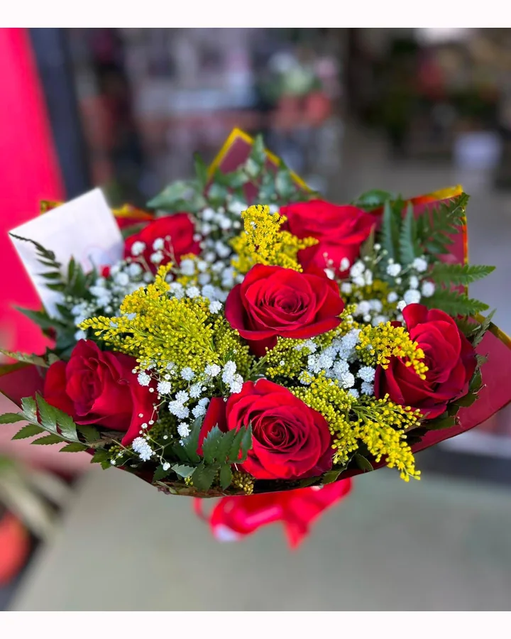 Buquê de rosas vermelhas com flores amarelas e folhagens