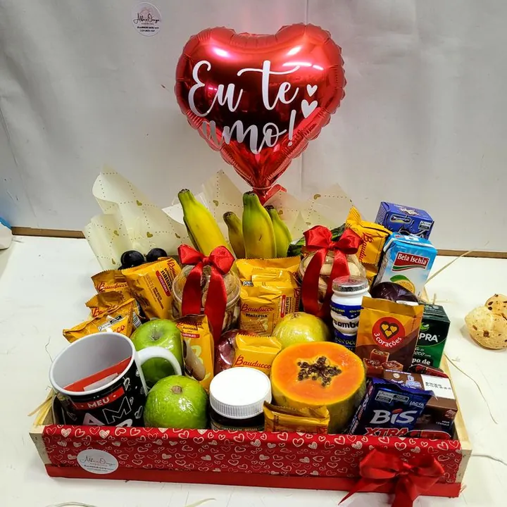 Cesta de café da manhã romântica com frutas, chocolates e balão